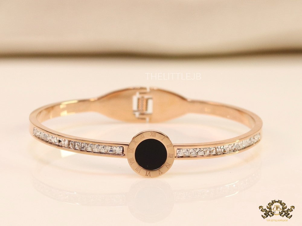 Rose gold plated cz bracelet with roman numerals inscribed on black centre motif