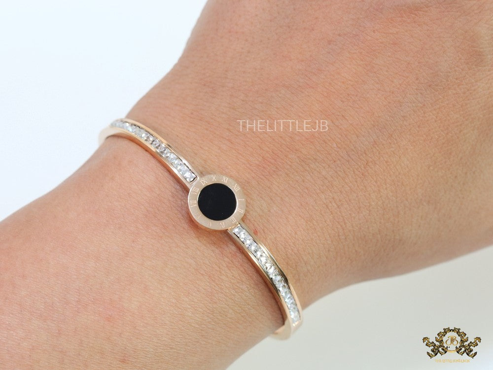 Rose gold plated cz bracelet with roman numerals inscribed on black centre motif