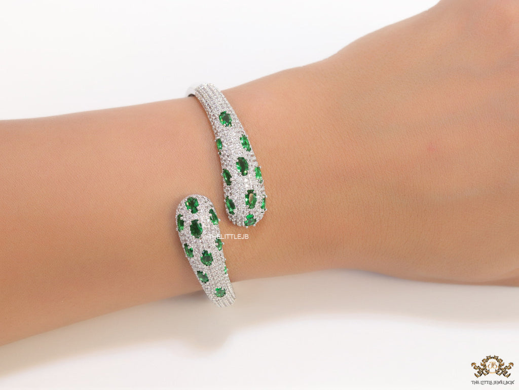Platinum plated open cz bracelet with emerald green stones