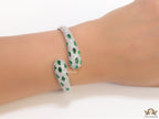 Platinum plated open cz bracelet with emerald green stones