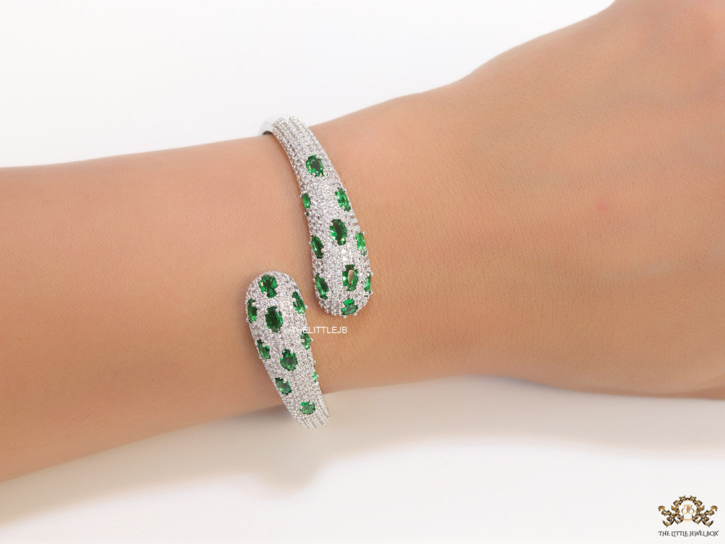 Platinum plated open cz bracelet with emerald green stones