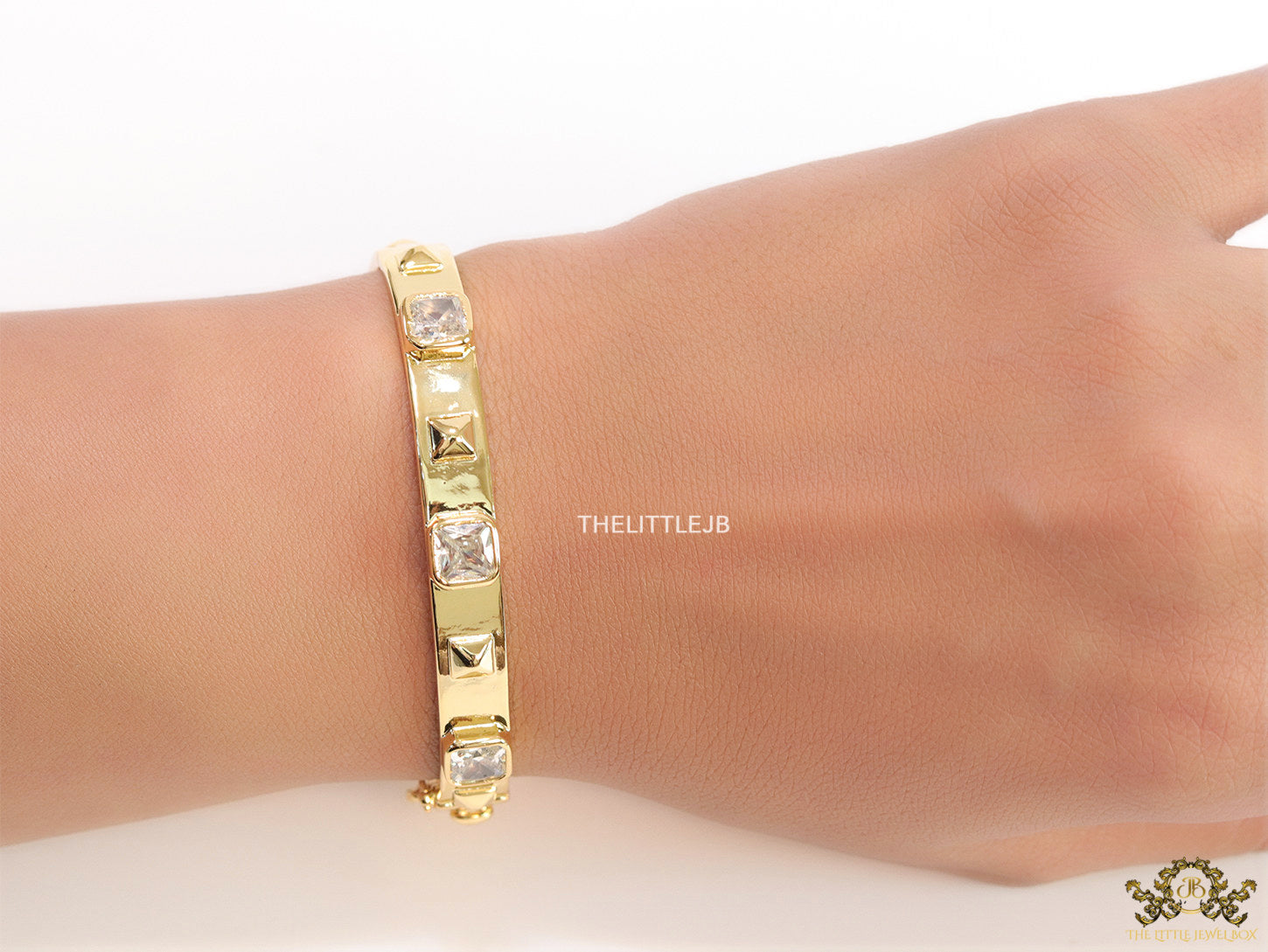 Band style bracelet in gold plating with gold plated details and cubic zirconia stones