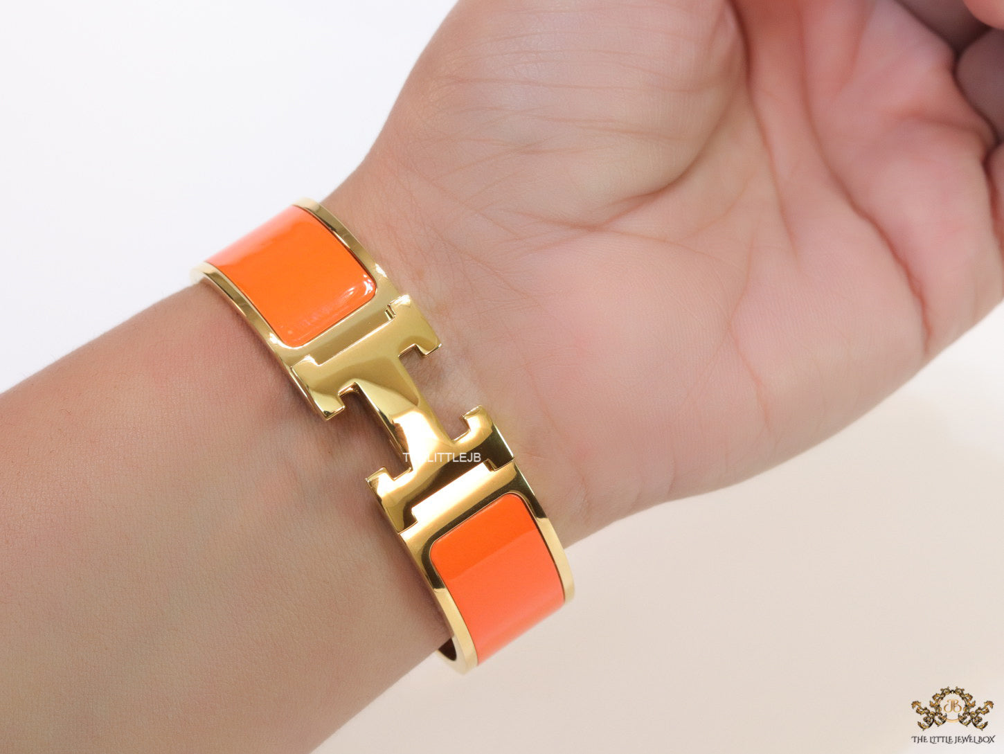Openable H motif orange bracelet 18mm wide in a shiny gold plating