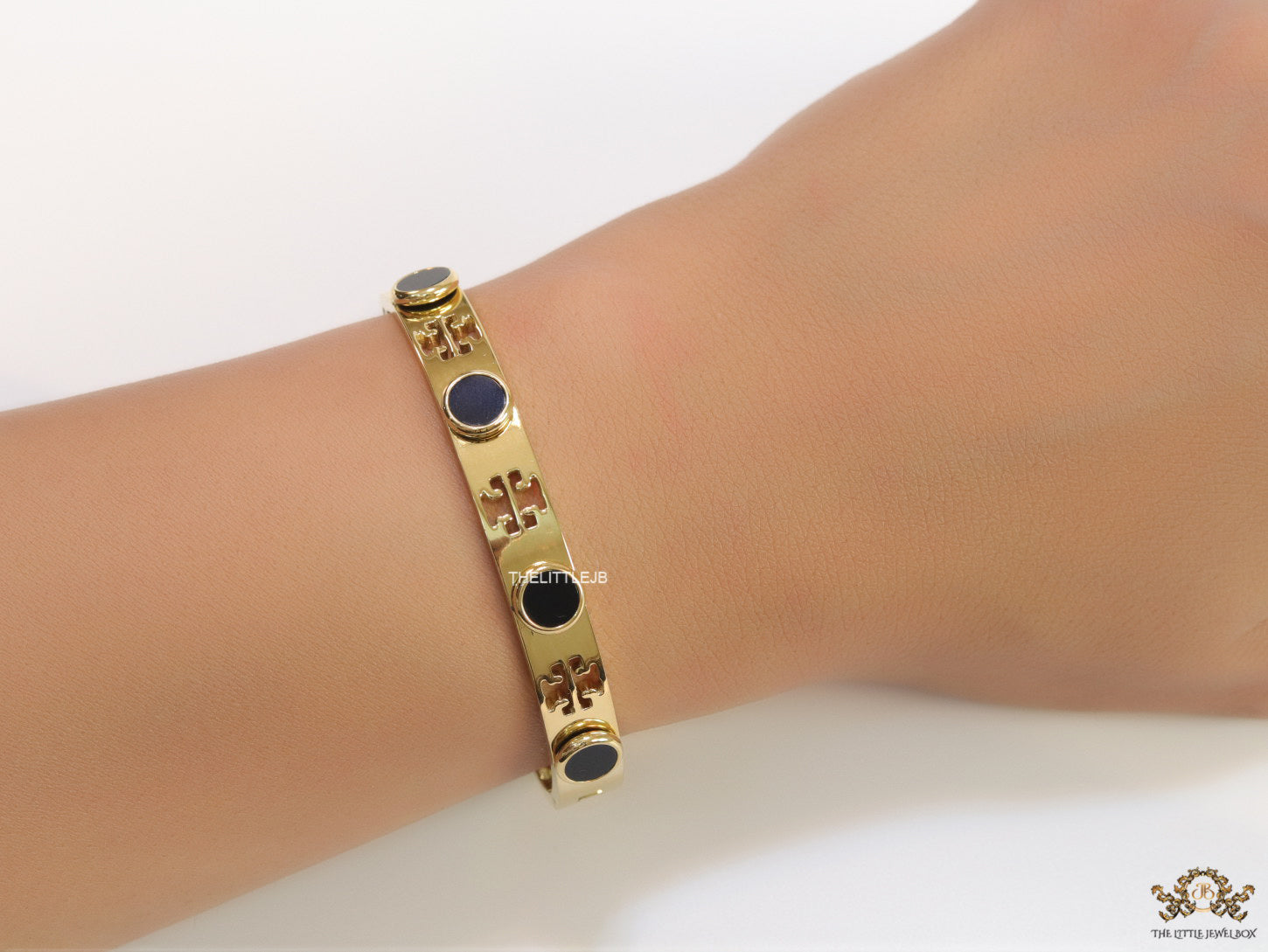 Gold plated cutwork twin T motif bracelet with black stones