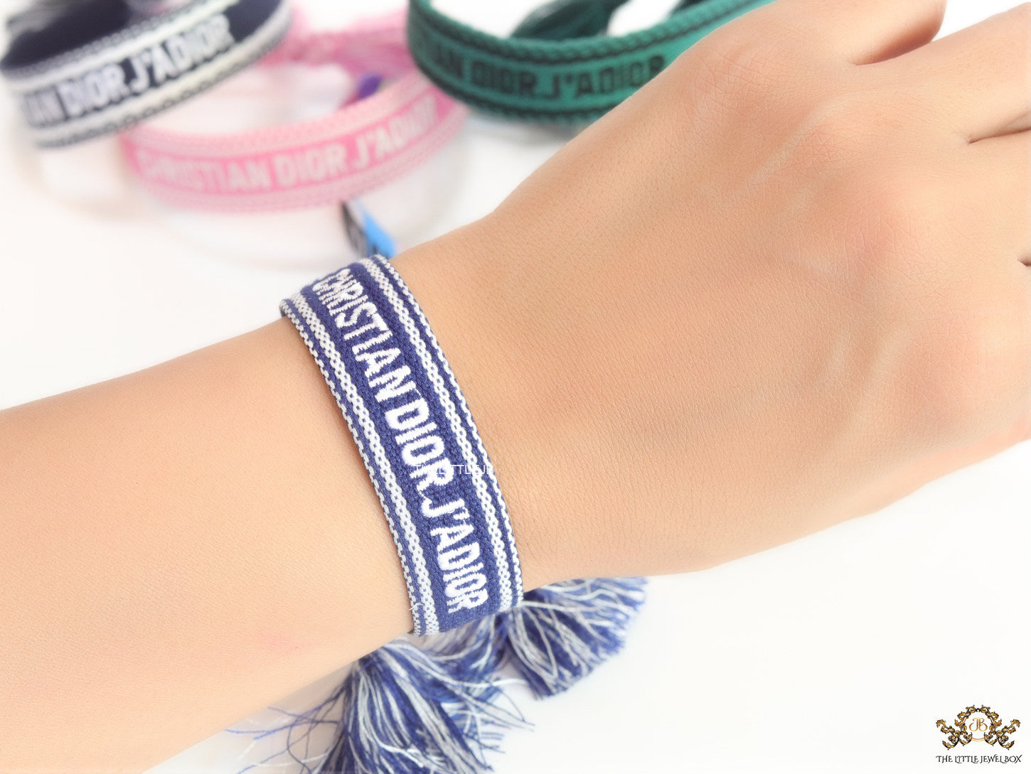 Adjustable blue woven bracelet with white knitted alphabets and tassels