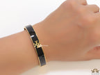 Golden and black bracelet with T motif