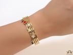 Multilayered golden bracelet with alphabets and coloured clover charms