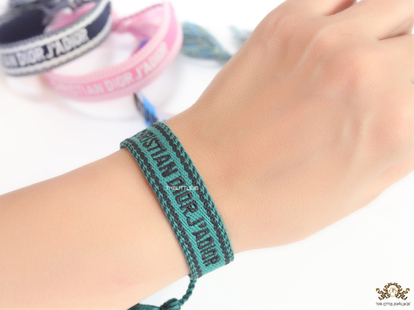 Adjustable green woven bracelet with black knitted alphabets and tassels