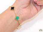 Golden chain bracelet with black and green clovers