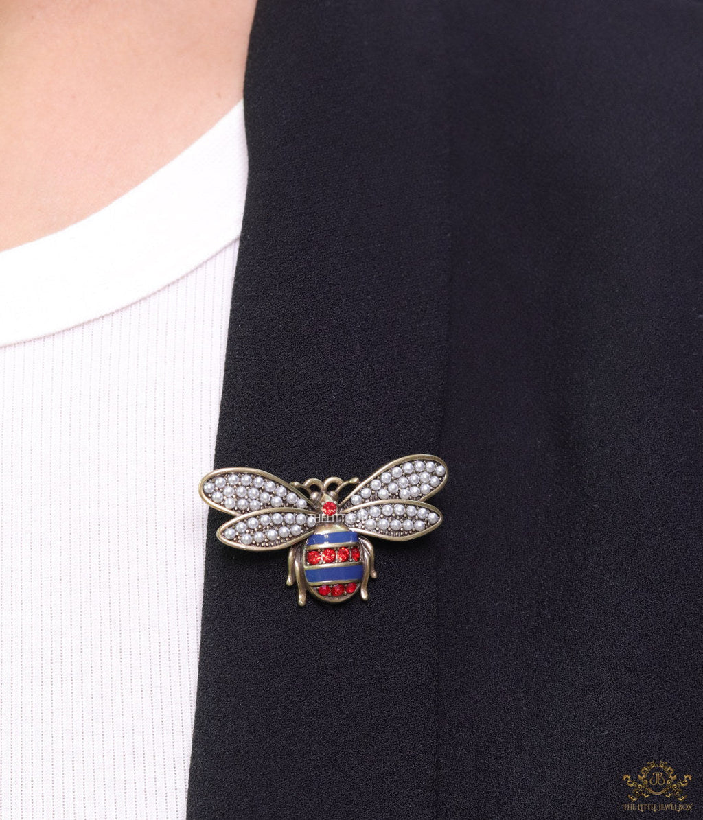 Antique gold finish bee brooch with white and red stones and blue details