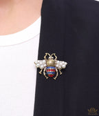 Antique gold finish double G bee brooch with blue details and white and red stones