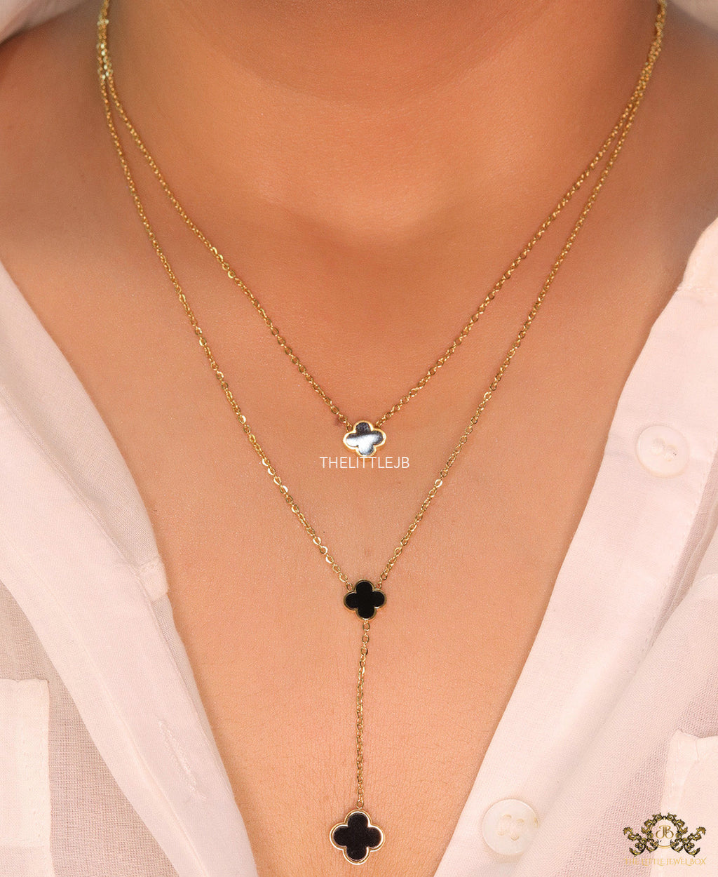 Dual chain necklace with black onyx clovers in gold finish