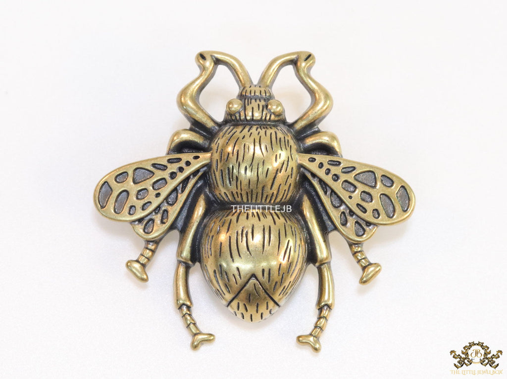 Antique gold finish bee brooch with white and red stones and blue details