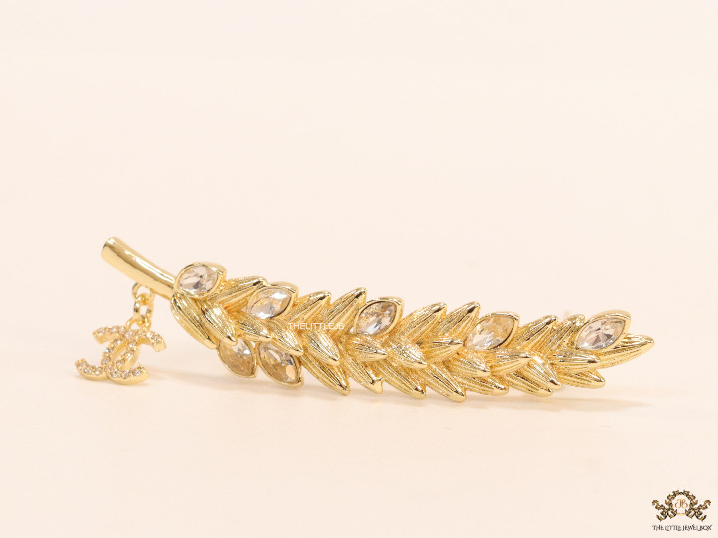 Golden feather brooch with fancy cz and twin C charm