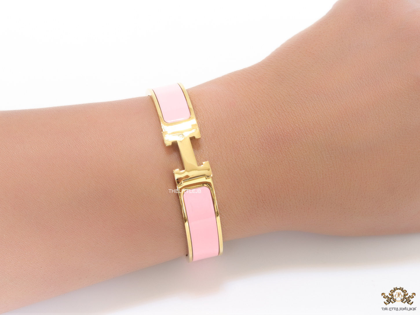 Premium range band style bracelet in pink colour with gold plated metallic details and gold plated T alphabet motif
