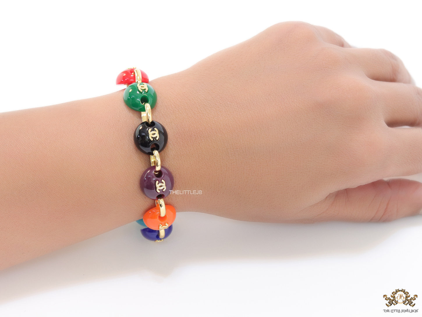 Gold plated link chain bracelet with multi coloured acrylic buttons with gold plated twin C alphabet