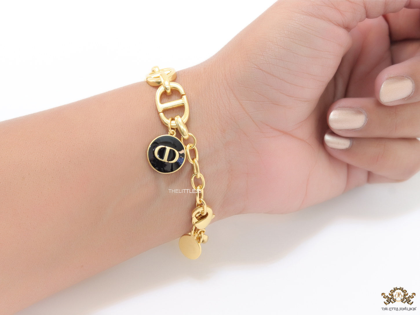 Gold plated link chain bracelet with charms, trinkets and black enamel charm with alphabets