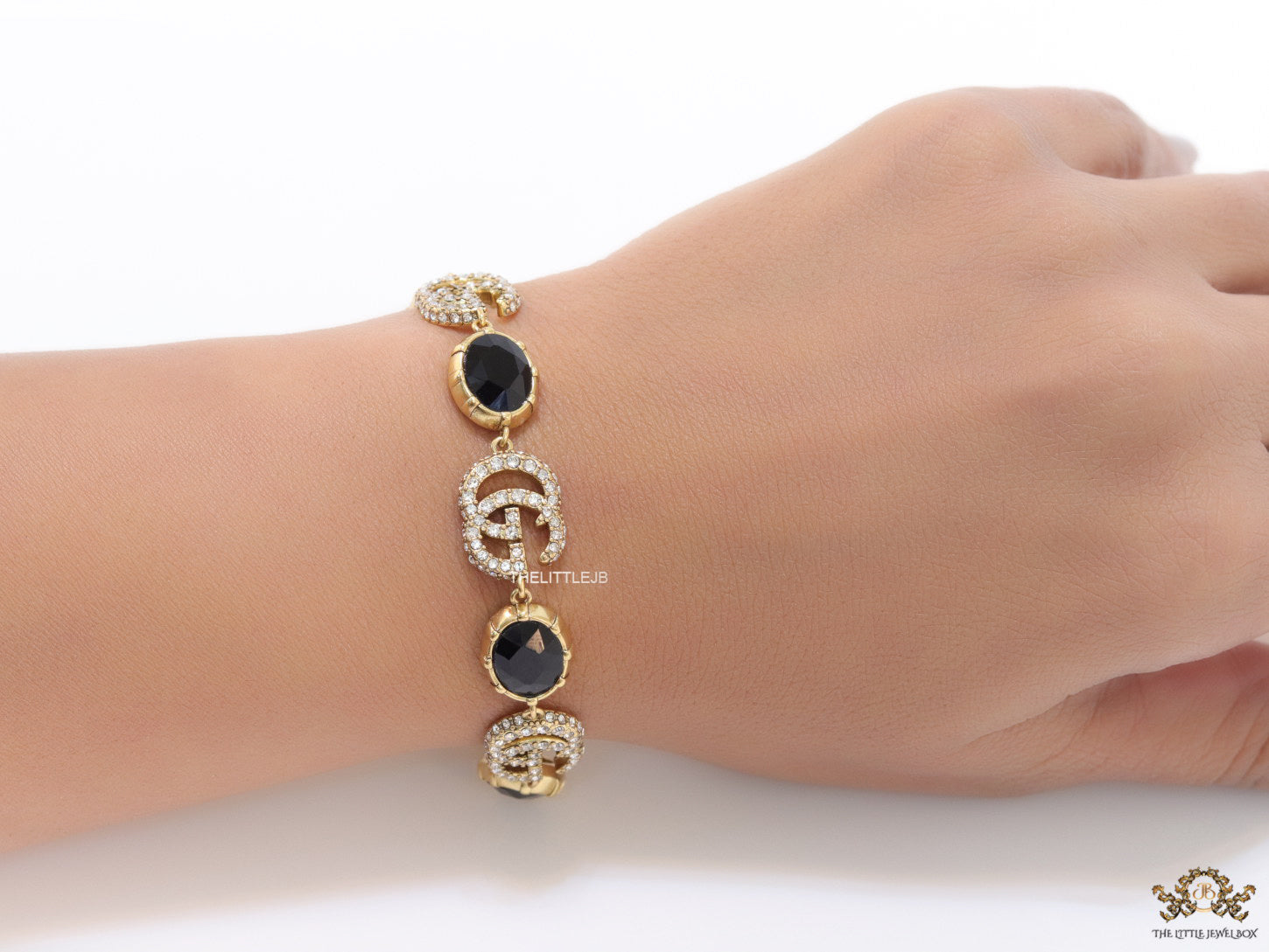 Gold plated linked chain bracelet with black stones and twin G alphabet motif