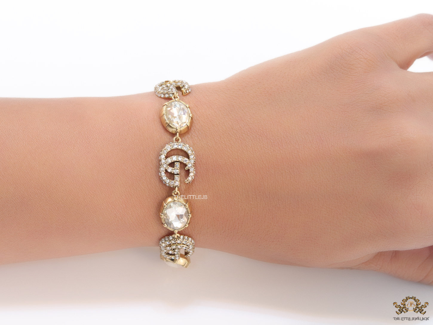 Gold plated linked chain bracelet with gold plated cubic zirconia stones twin G alphabet motifs and gold plated cubic zirconia stones