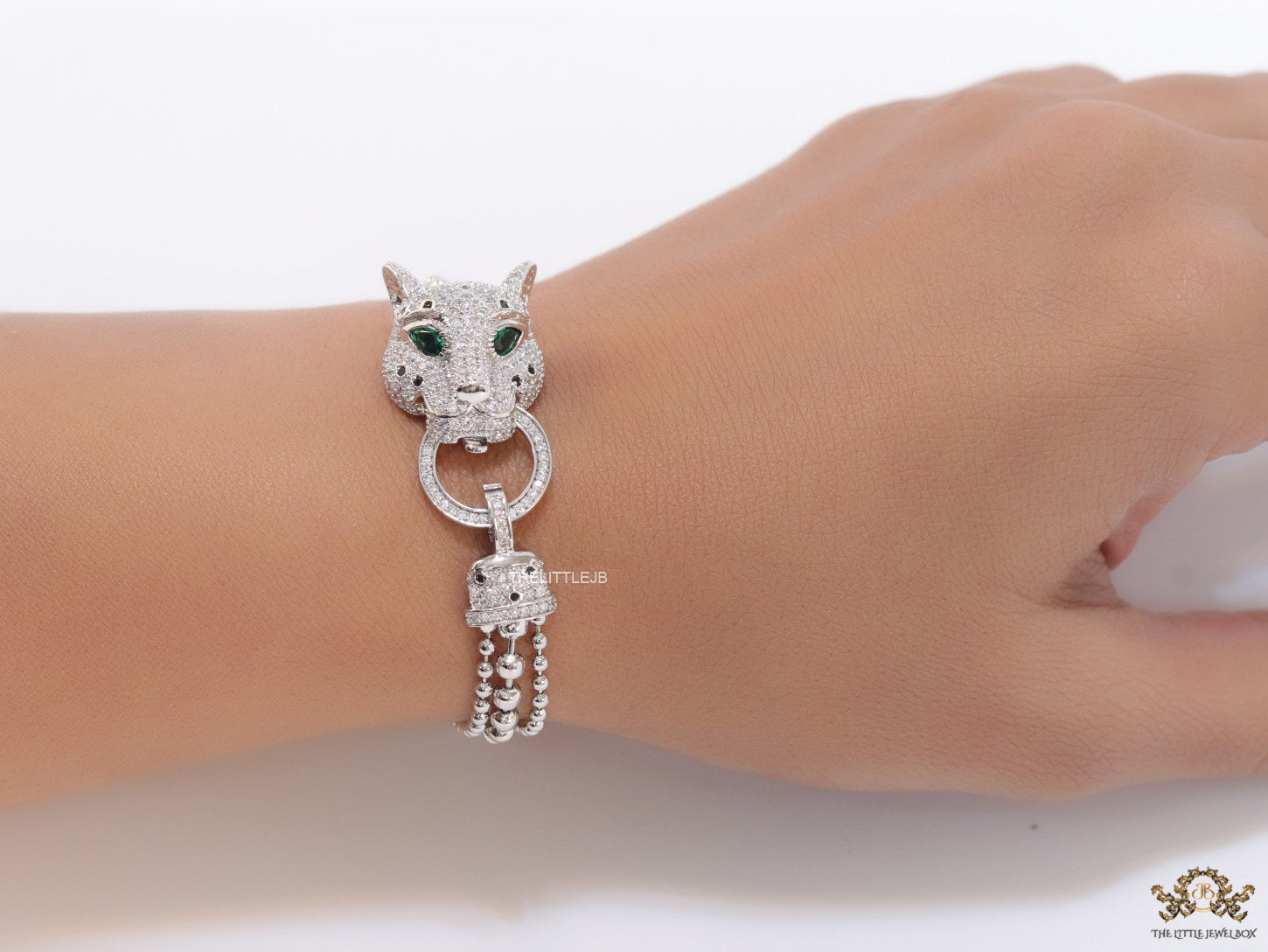 Platinum plated bracelet with cubic zirconia stones panther face motif with green cubic zirconia stone details and cubic zirconia stones disc