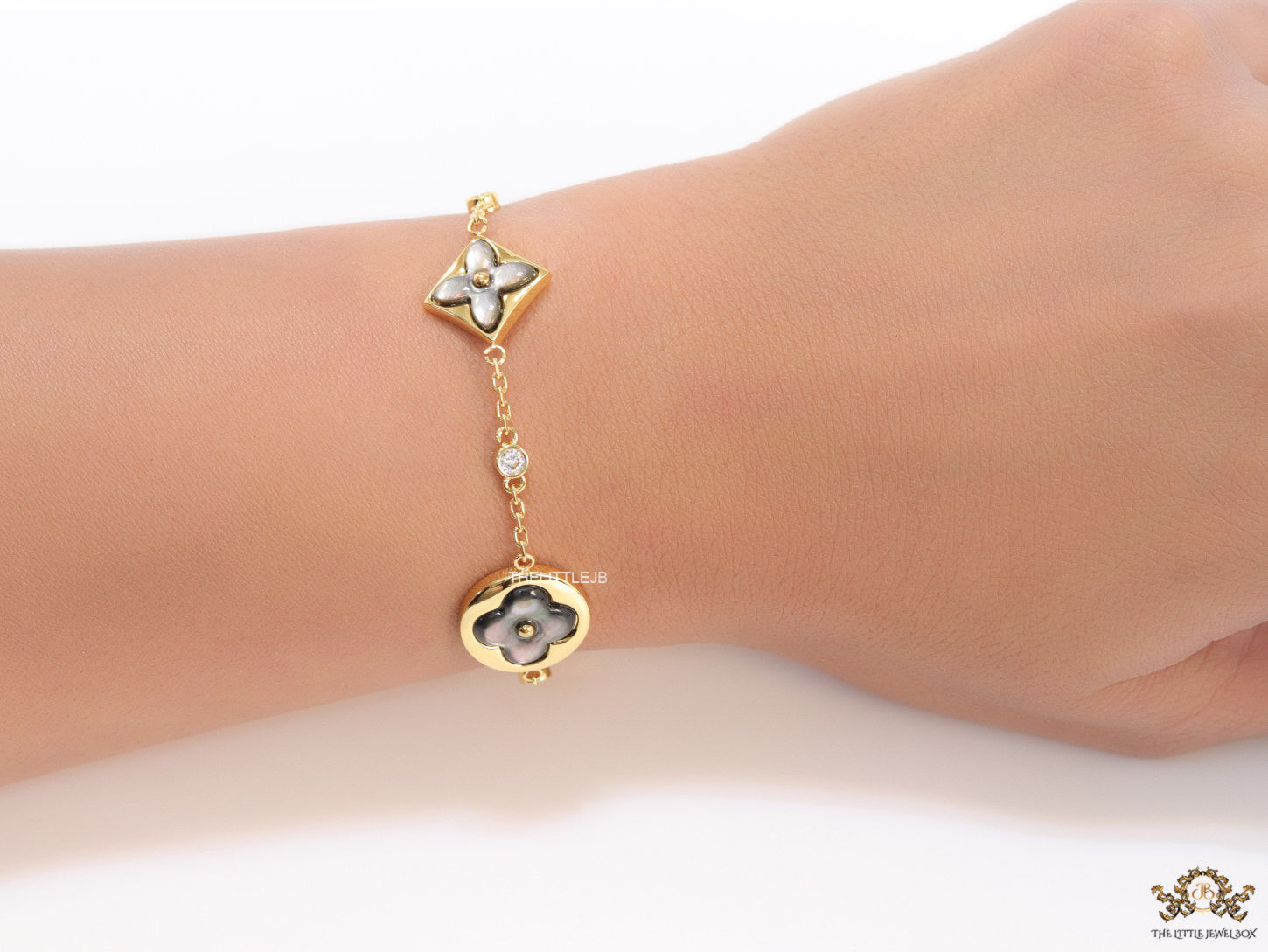 Sleek gold plated chain style bracelet with gold plated grey mother of pearl flower designs