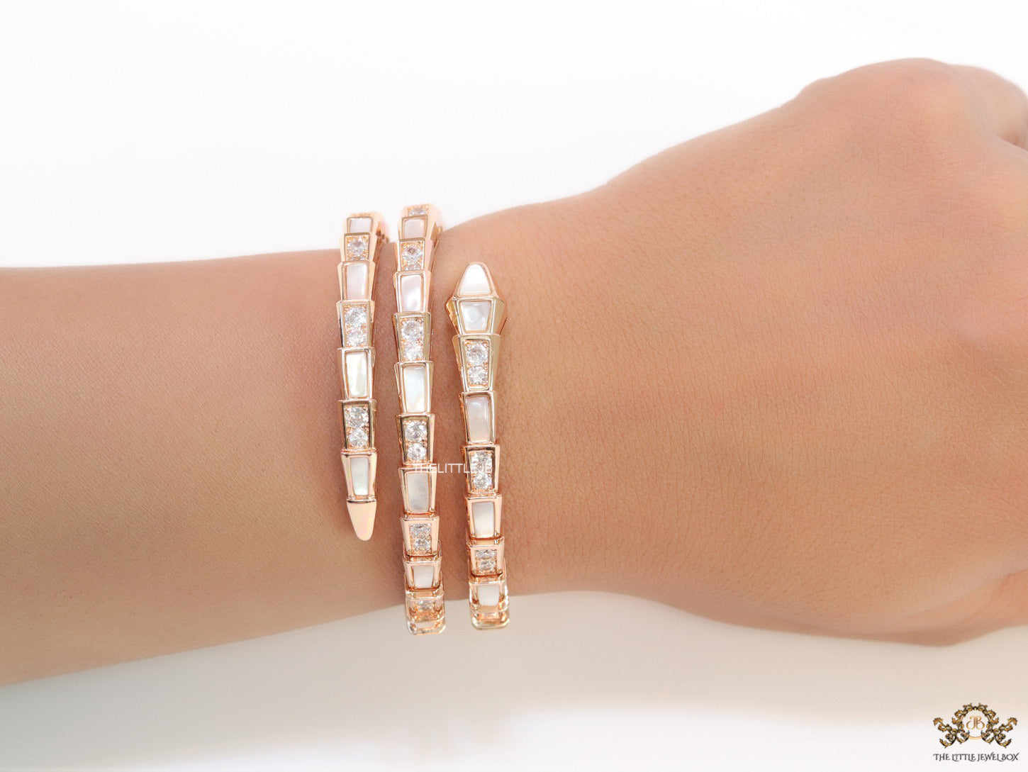 Triple line rose gold plated minimal serpentine bracelet with cubic zirconia stones and pearl white stones.