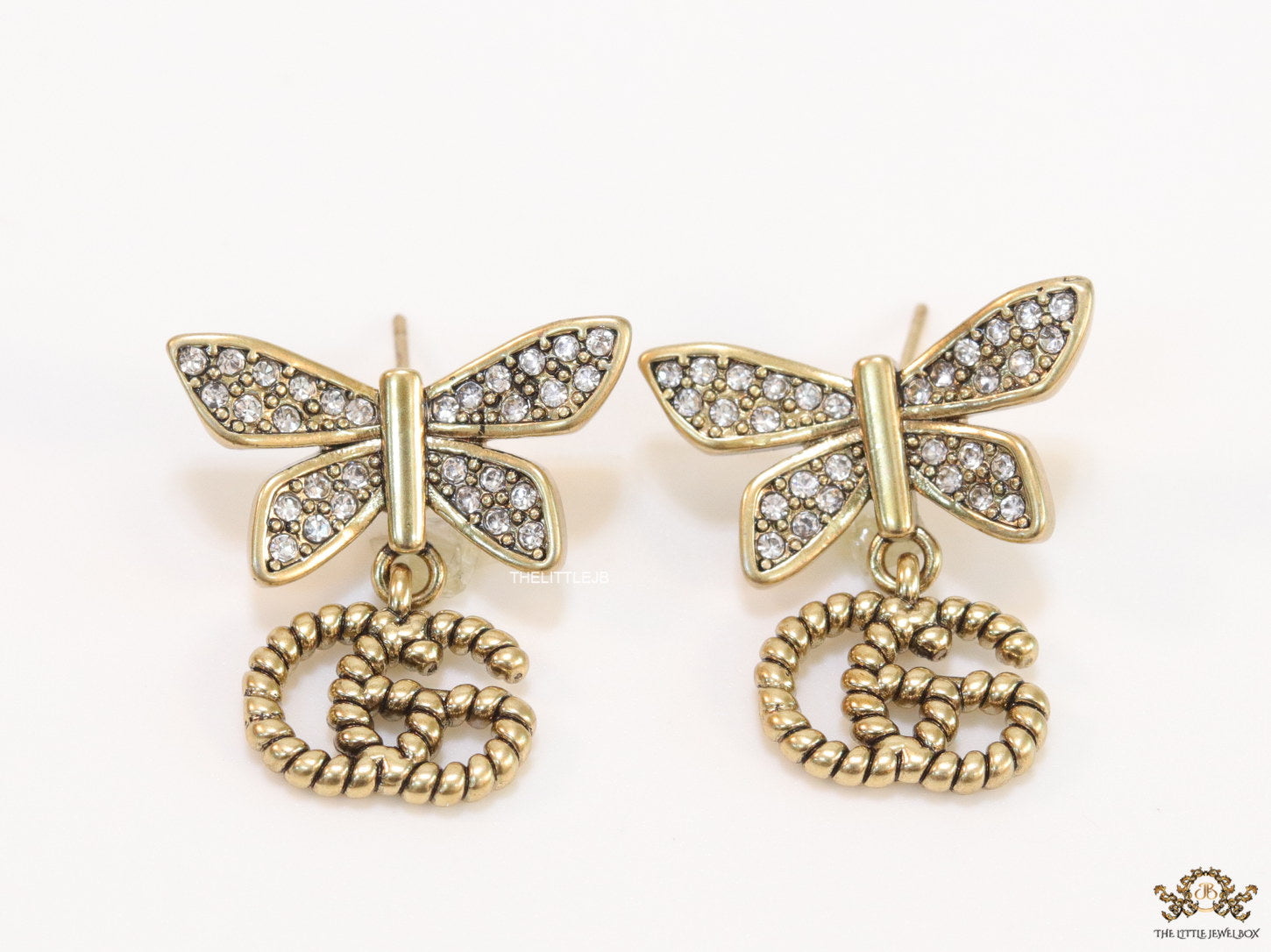 Studed cubic zirconia stone butterfly studs with textured double G motif drop