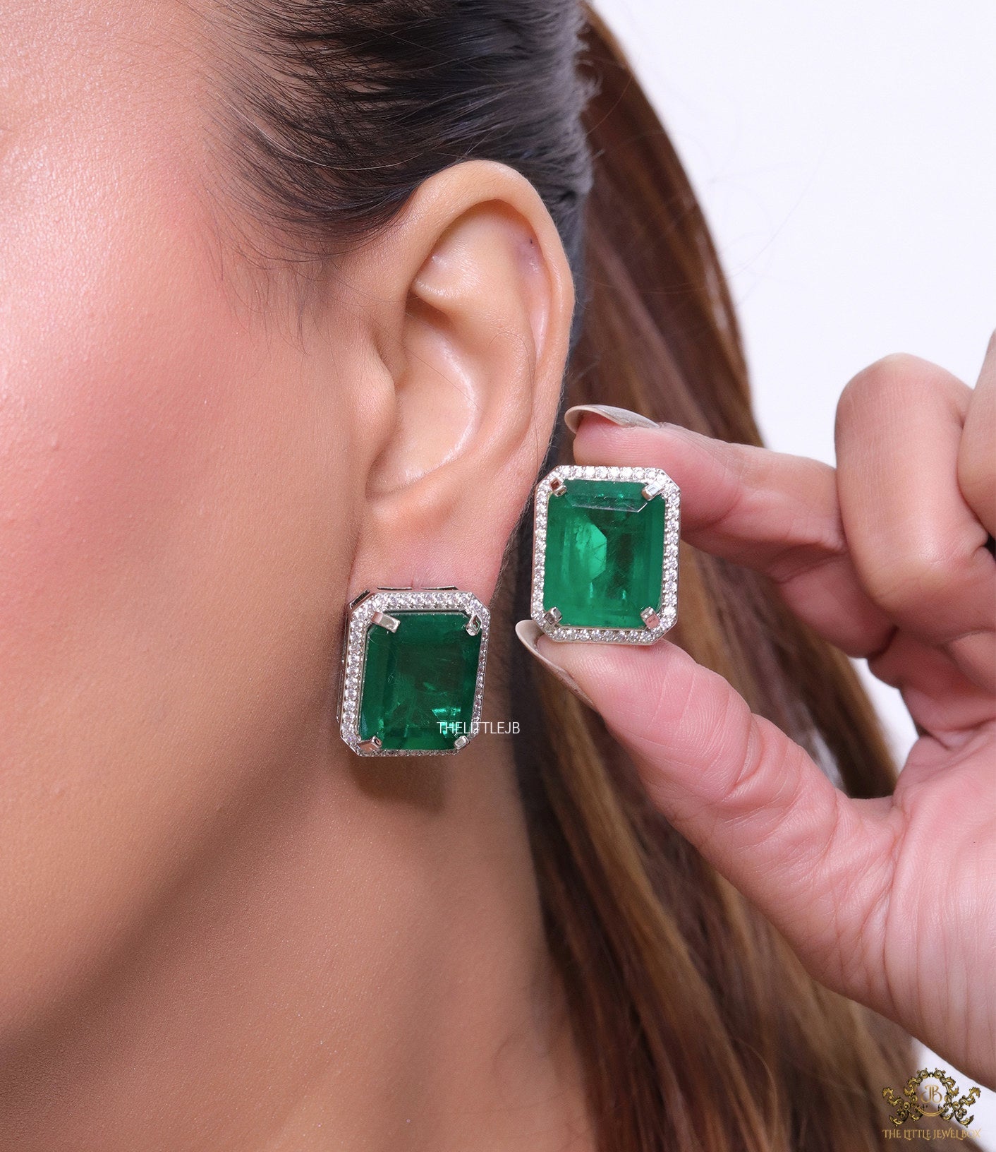 Platinum plated studs with emerald green doublet stone and white cubic zirconia stones lining
