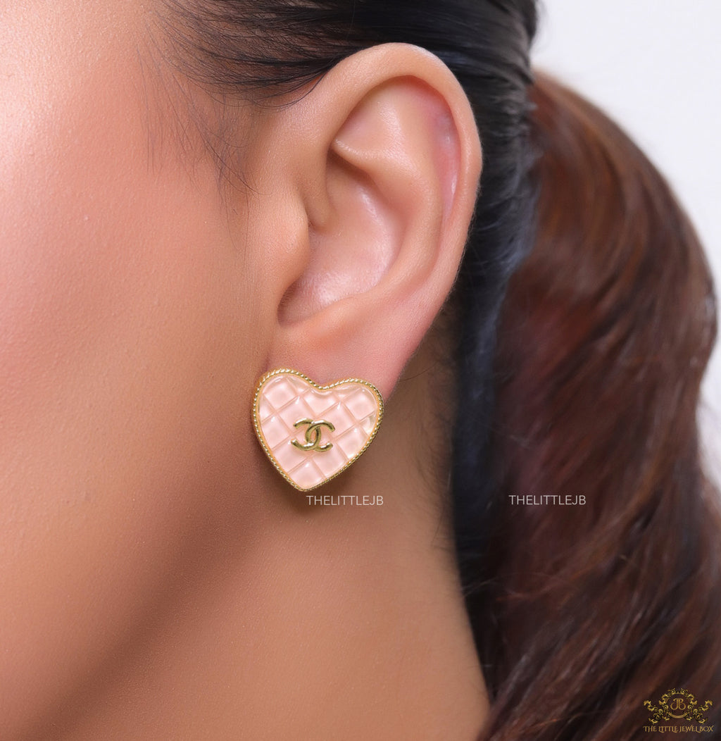 Light pink textured heart shaped studs with twin C motif in golden finish