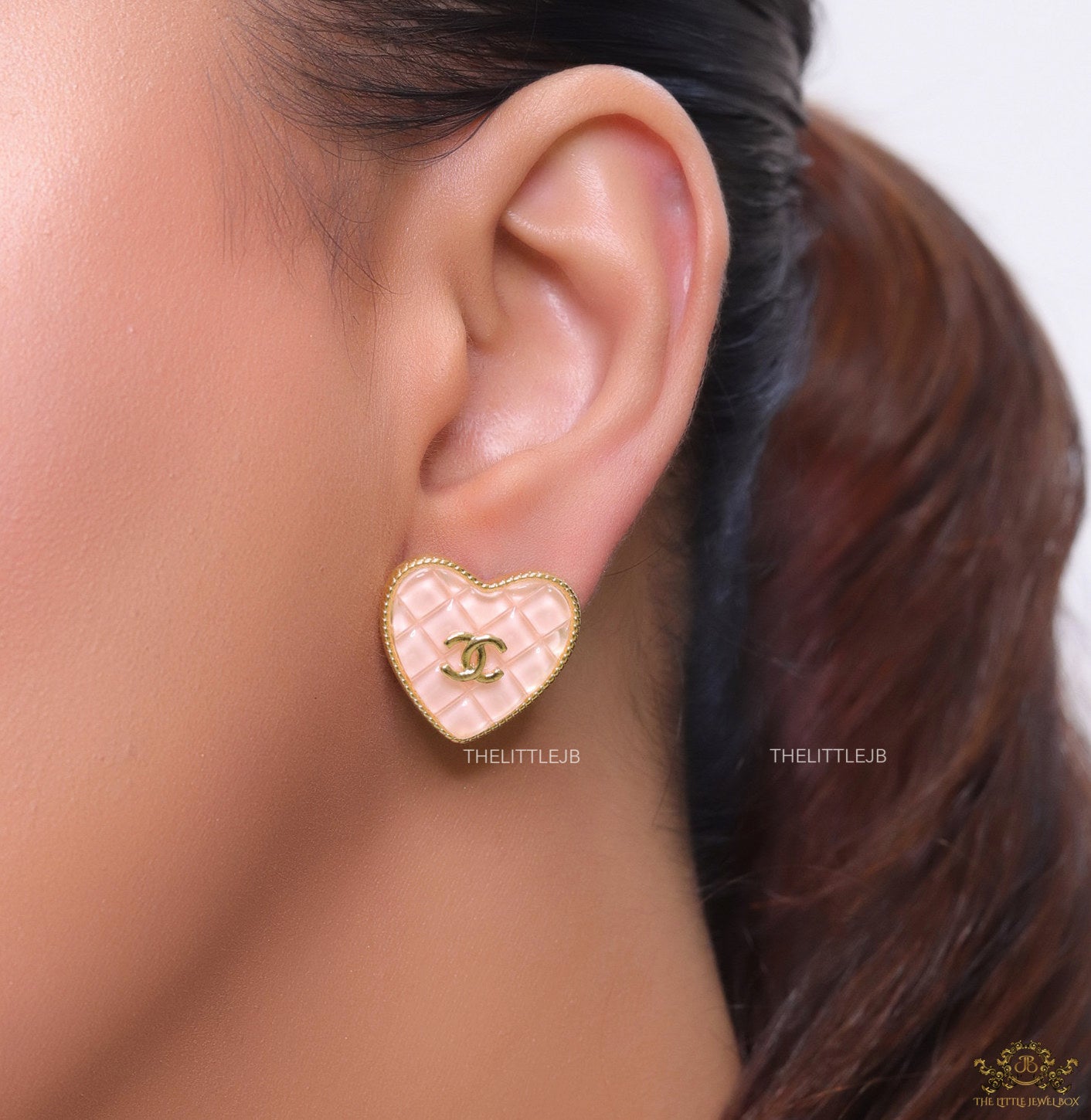 Light pink textured heart shaped studs with twin C motif in golden finish