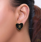 Black textured heart shaped studs with twin C motif in golden finish