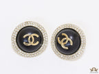 Round black stud earrings with golden twin C motifs lined with cz
