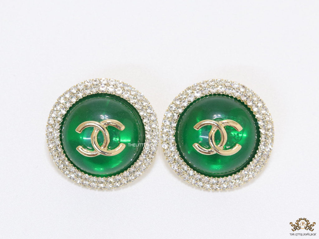 Round green stud earrings with twin C motifs lined with cz