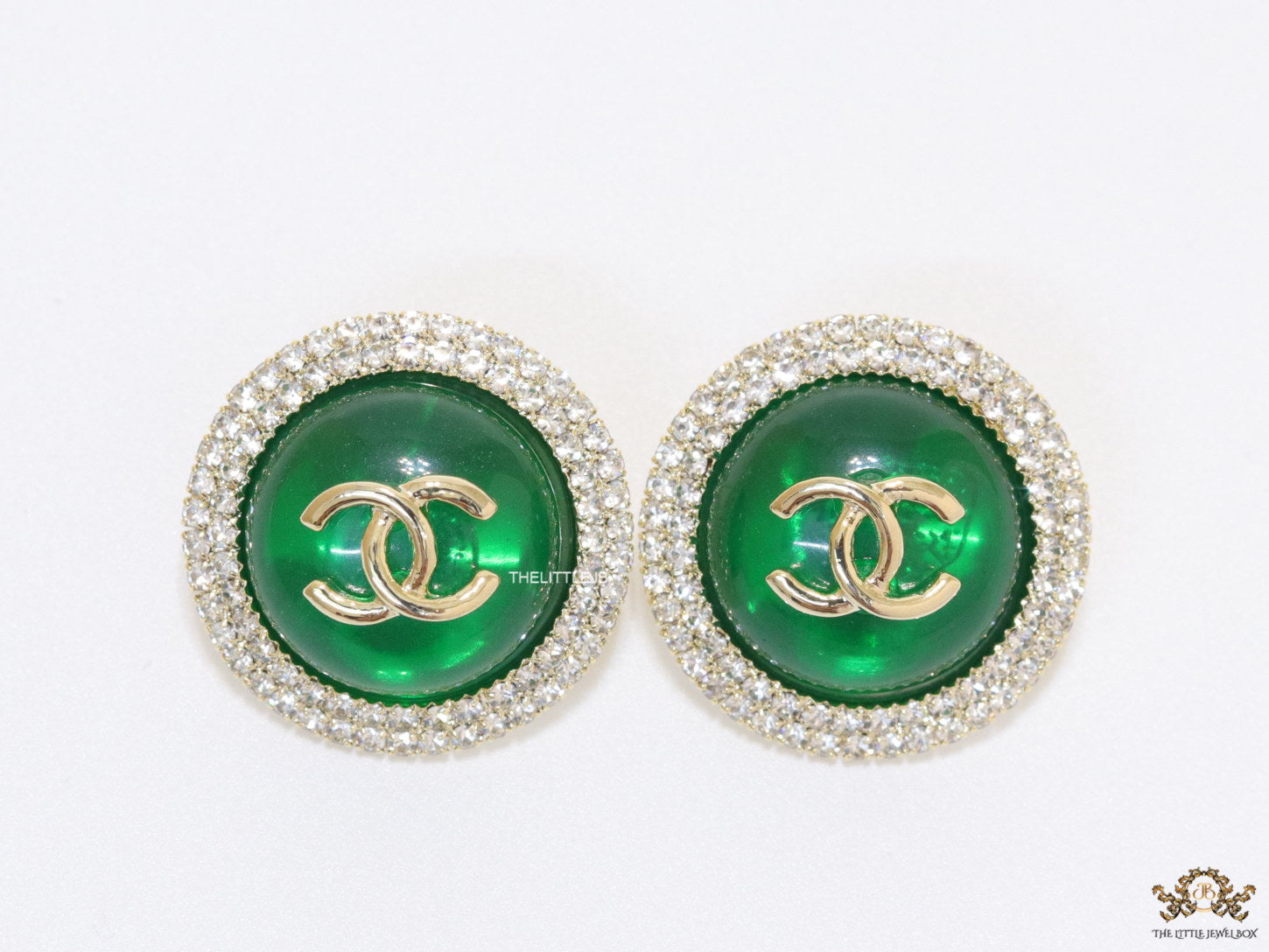 Round green stud earrings with twin C motifs lined with cz