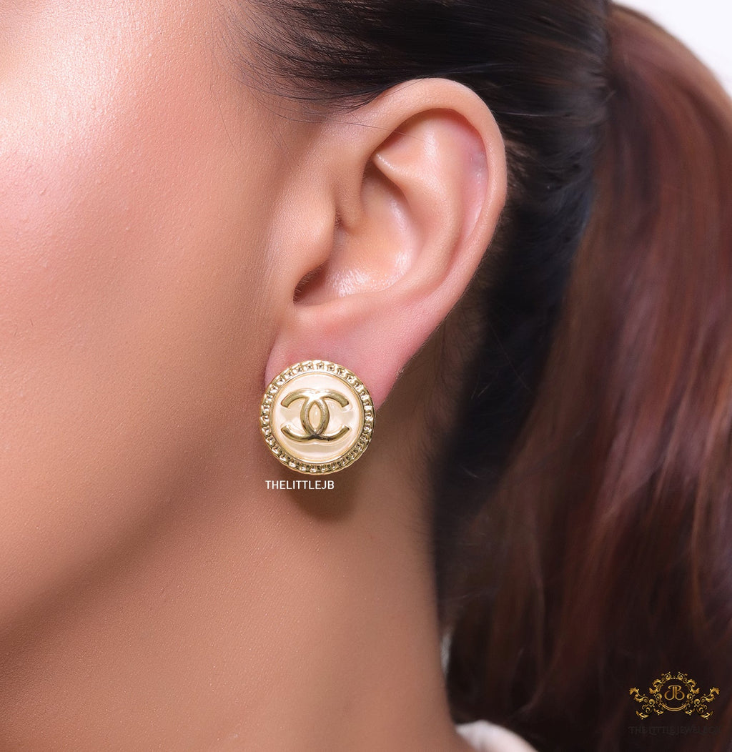 Twin C motif gold plated round studs on pearly cream acrylic base