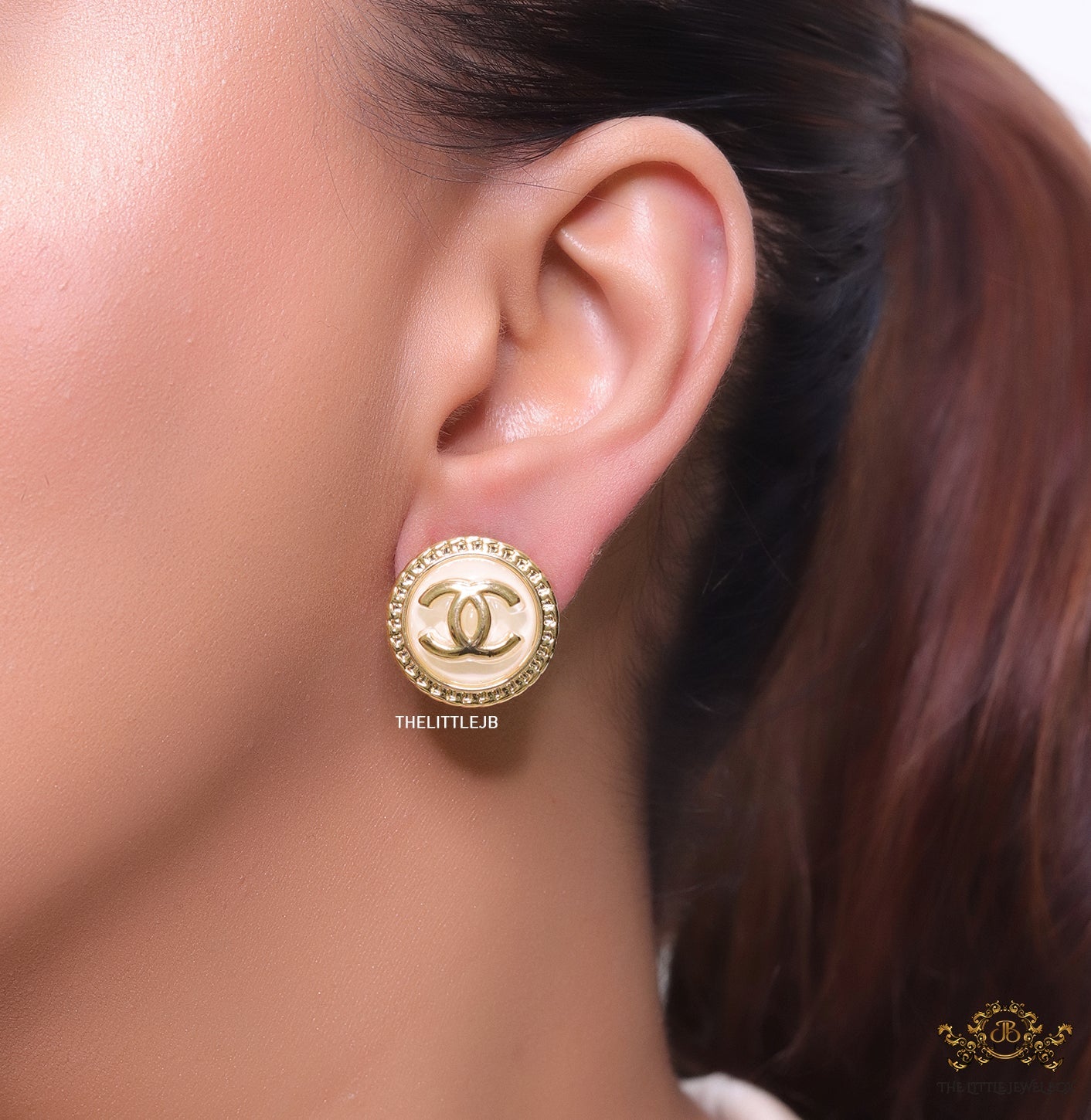 Twin C motif gold plated round studs on pearly cream acrylic base