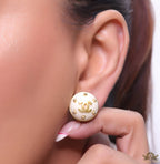White and golden round studs with twin C motif