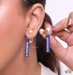 Blue silicon lapel drops with branding on pearl bomber studs