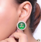 Round green stud earrings with twin C motifs lined with cz