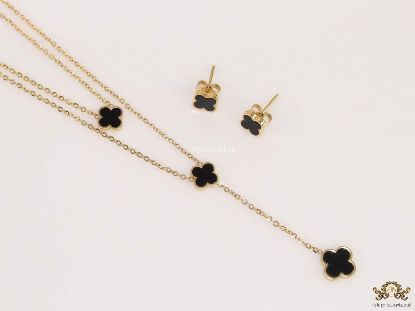 Dual chain necklace with black onyx clovers in gold finish