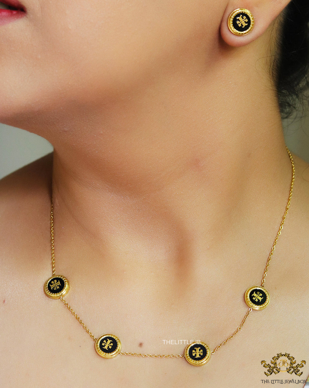 Gold plated necklace set with T motif black enamel coated discs