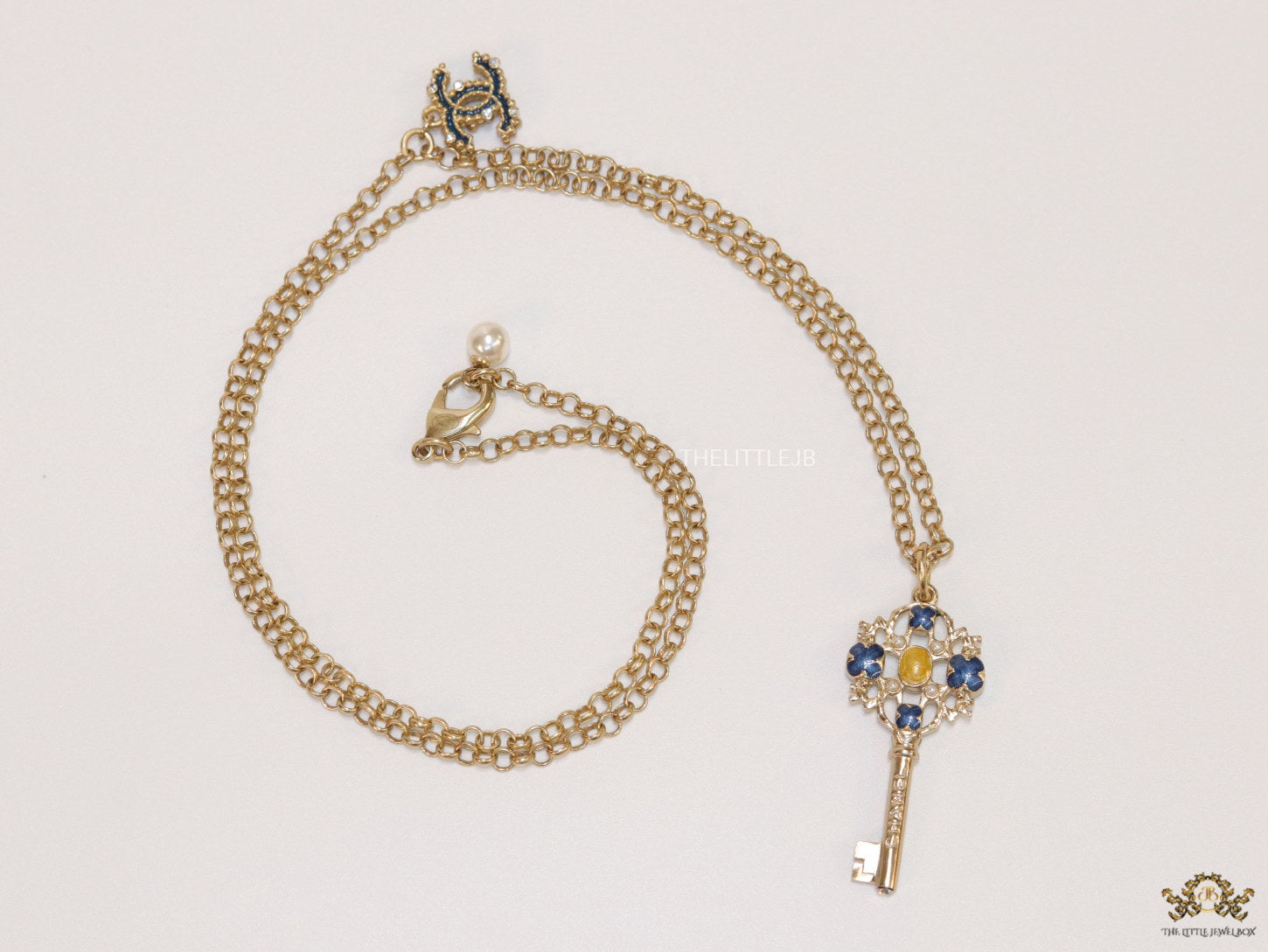 Golden chain necklace with blue clovers studded key pendant