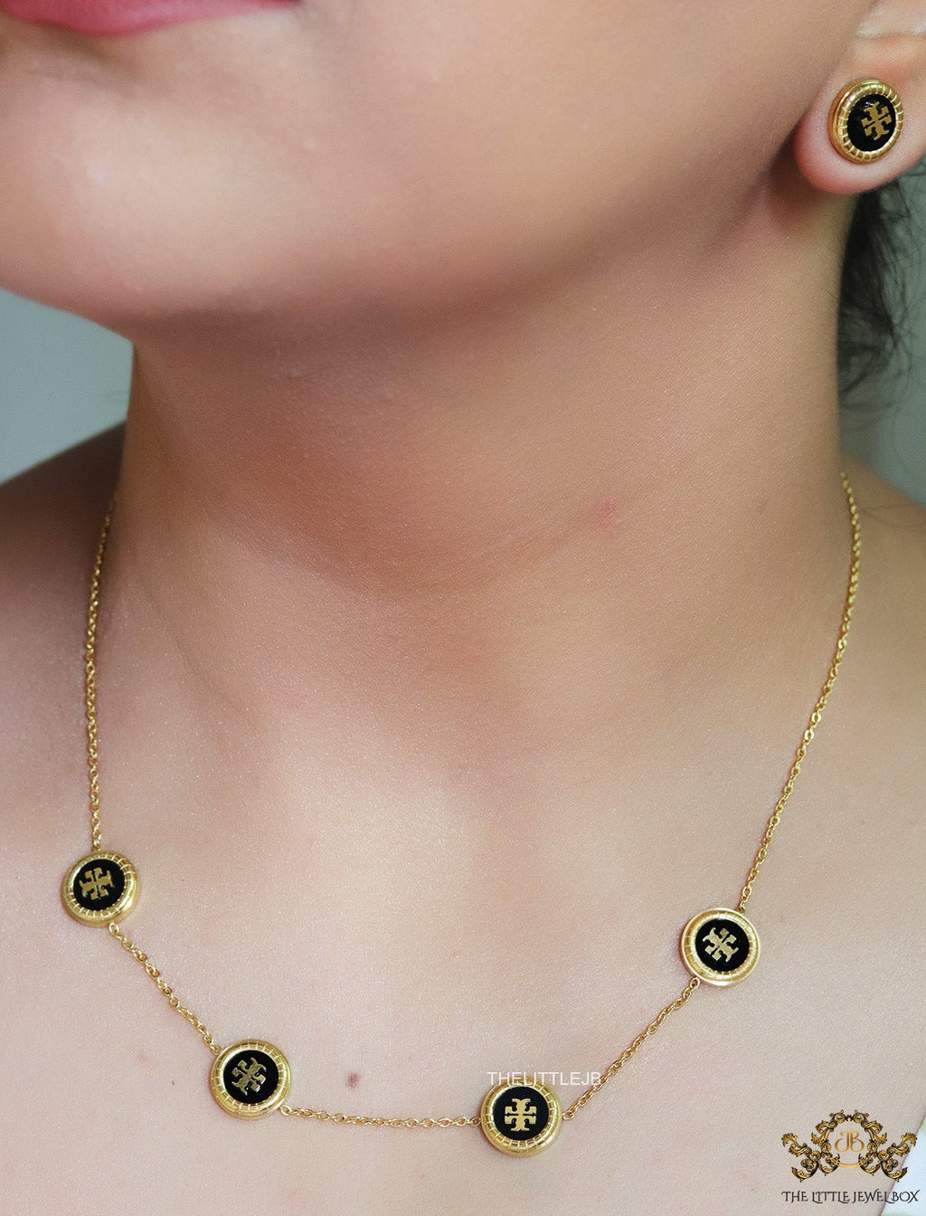Gold plated necklace set with T motif black enamel coated discs