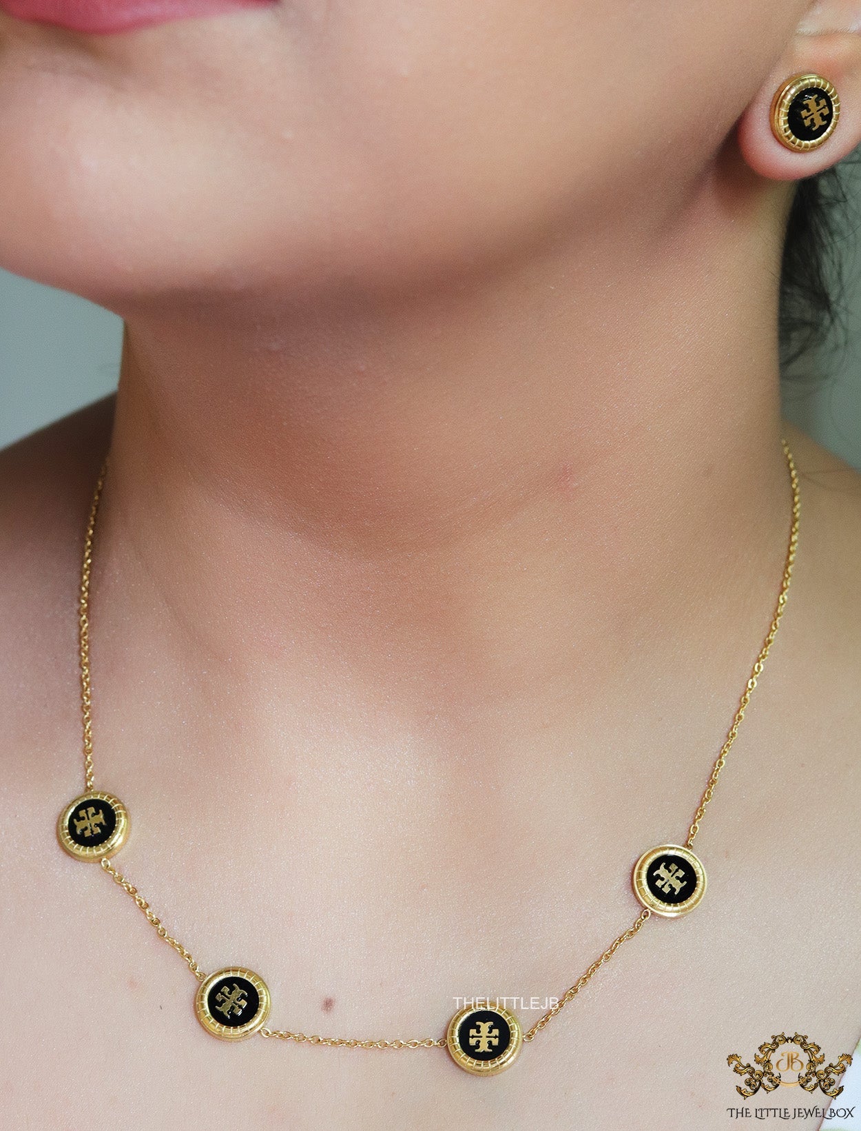 Gold plated necklace set with T motif black enamel coated discs