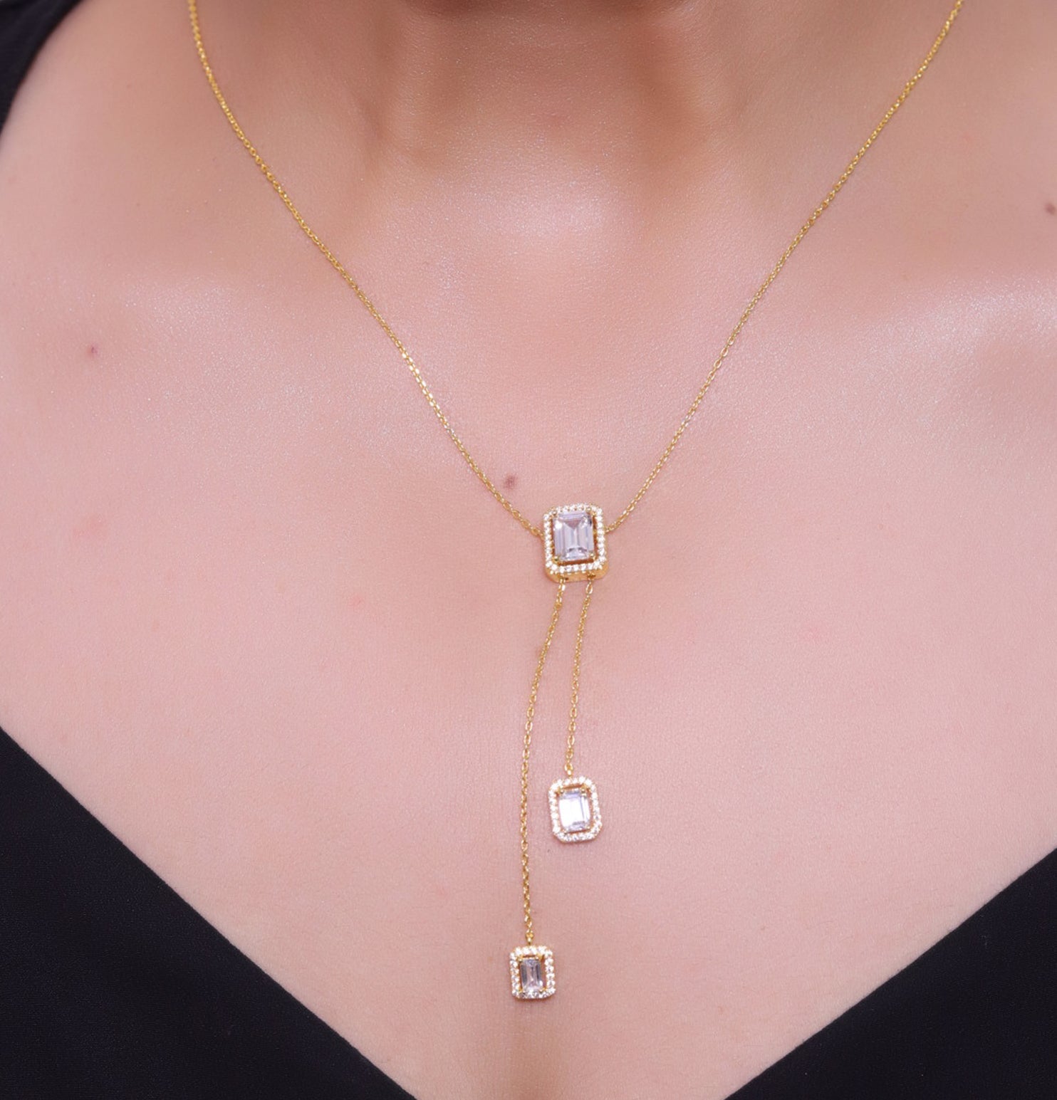 Emerald cut cubic zirconia stones in different sized on sleek gold plated chain