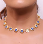 Gold plated link chain with blue cubic zirconia stones and gold plated Medusa motif charm.