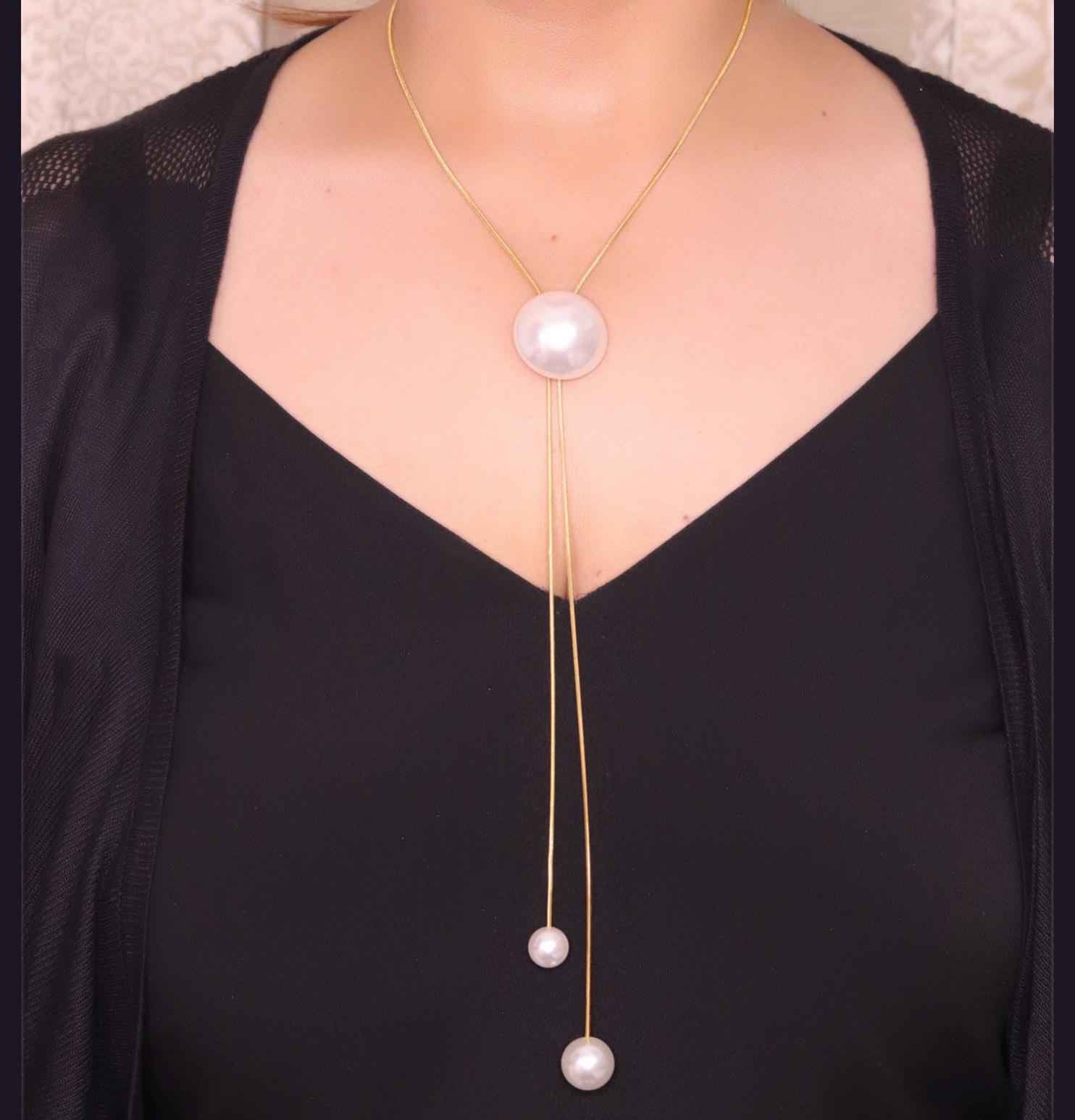 Sleek gold plated chain with different sized shell pearls.