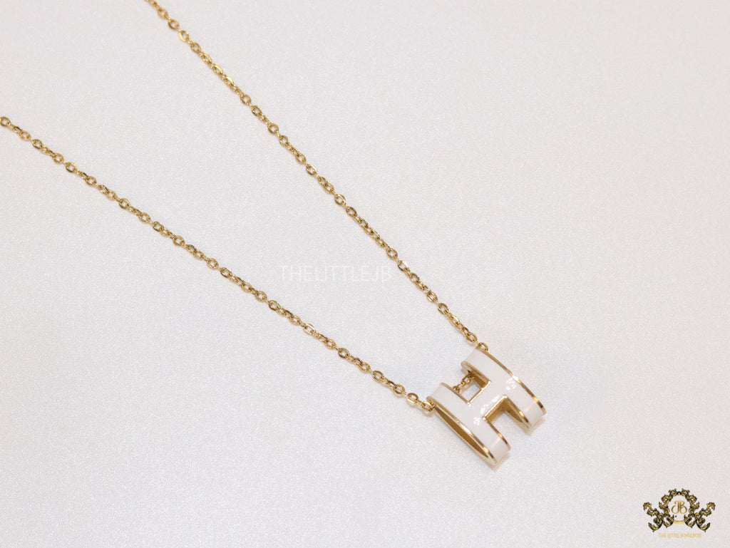 Gold chain necklace with white enamel H motif