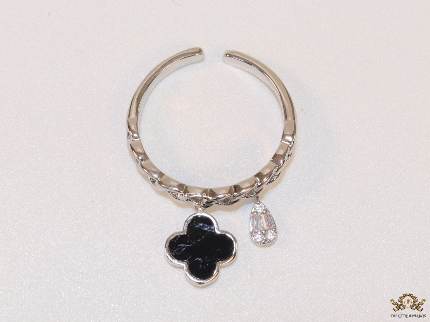Platinum plated link chain ring with black clover and cz drop