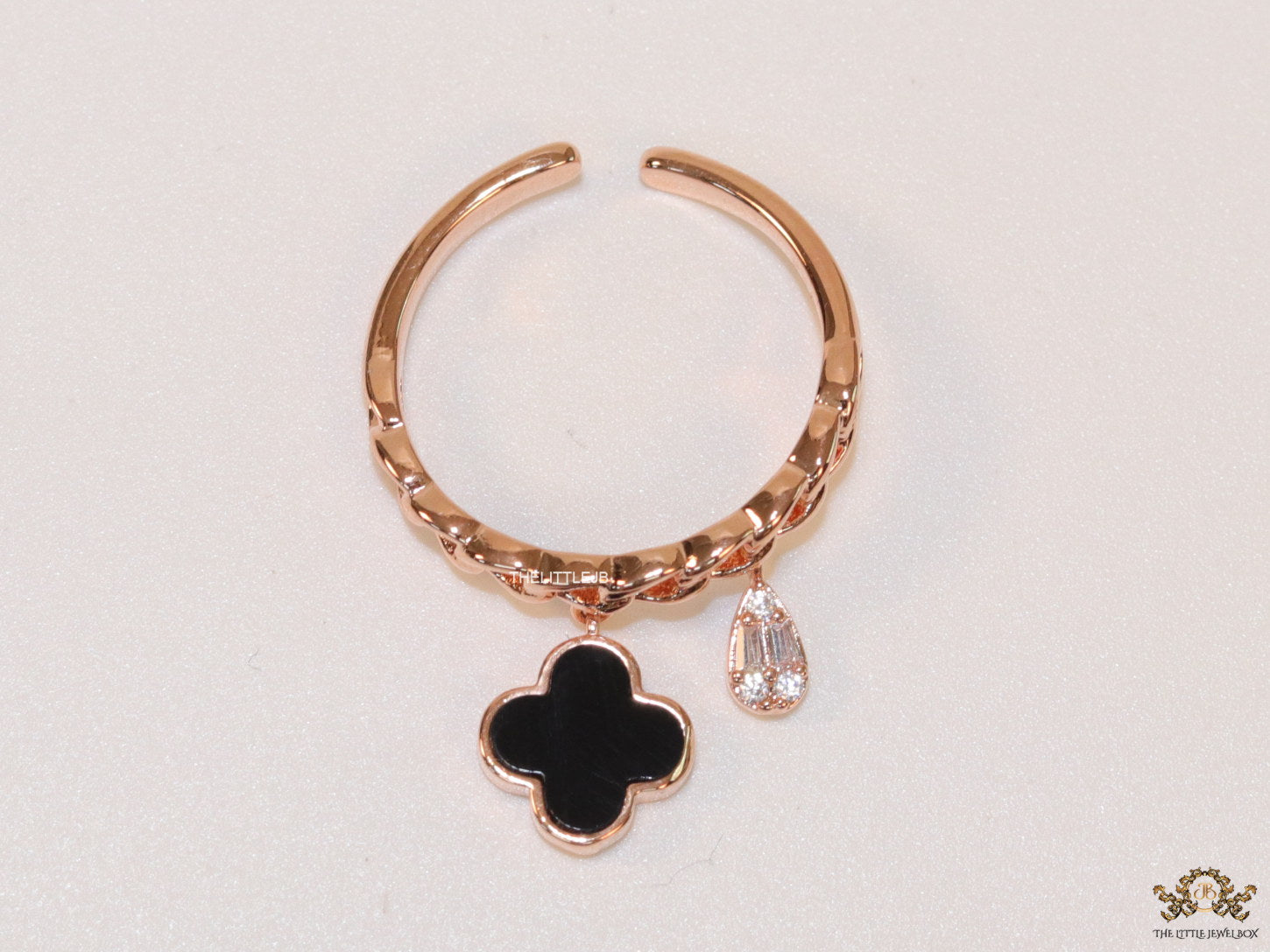 Rose gold plated link chain ring with black clover and cz drop